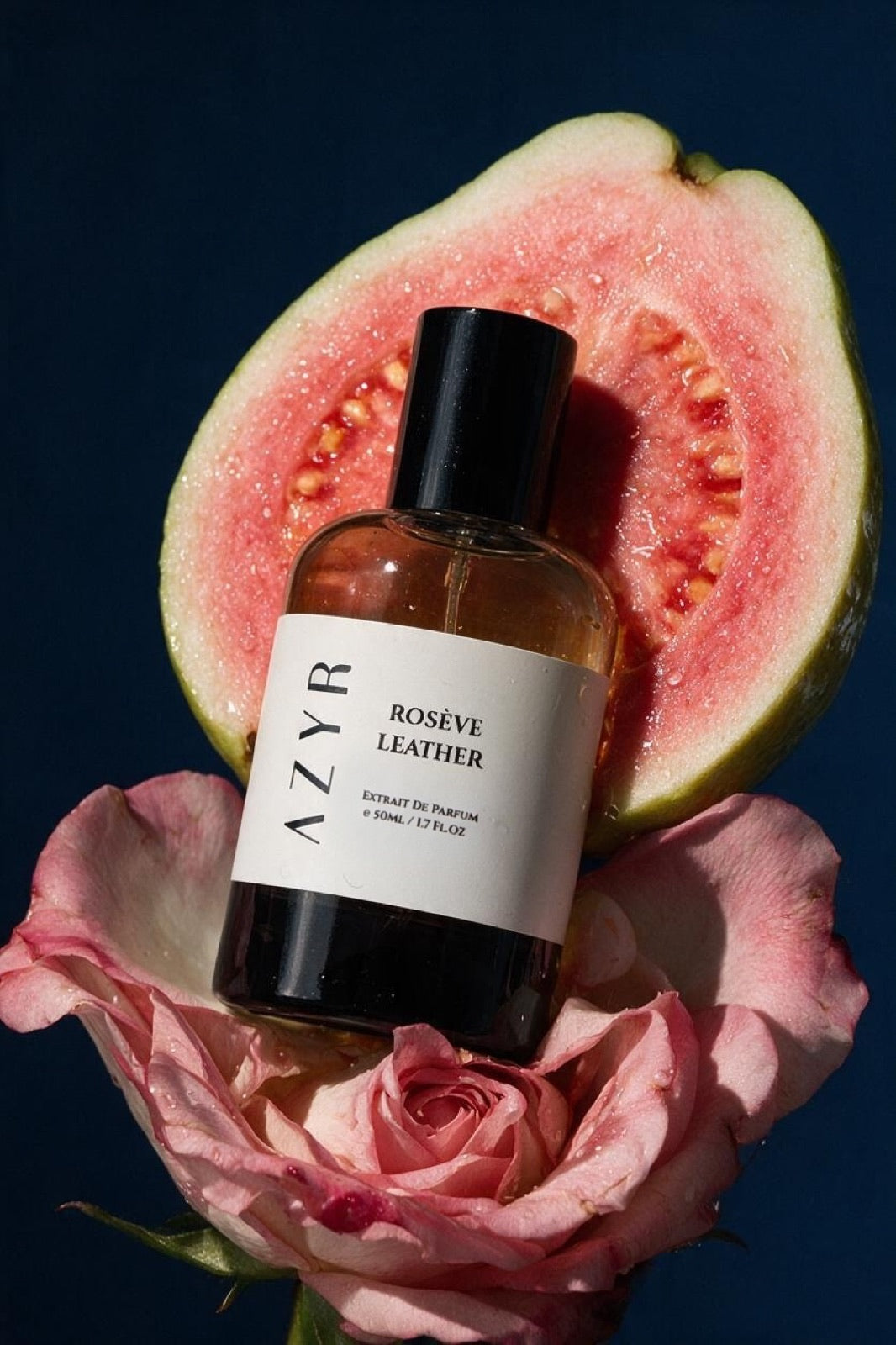 Rosève Leather bottle on a pink rose and a halved guava