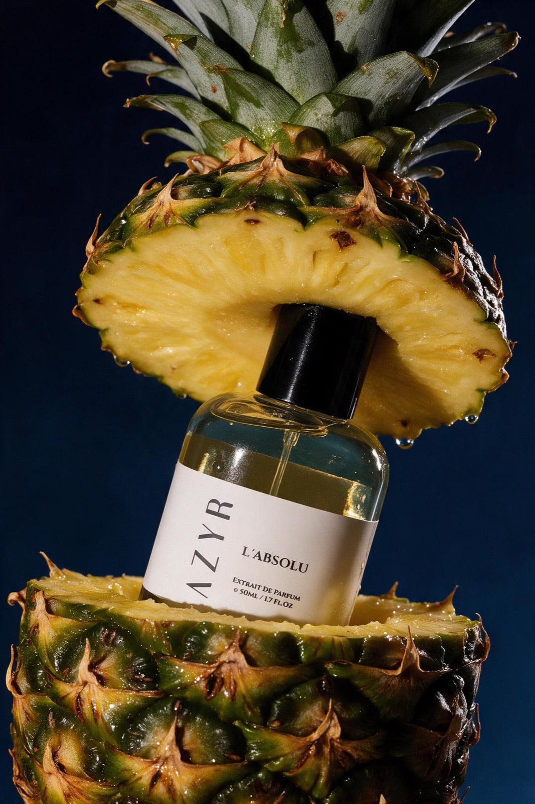 L'Absolu bottle between two halves of a pineapple